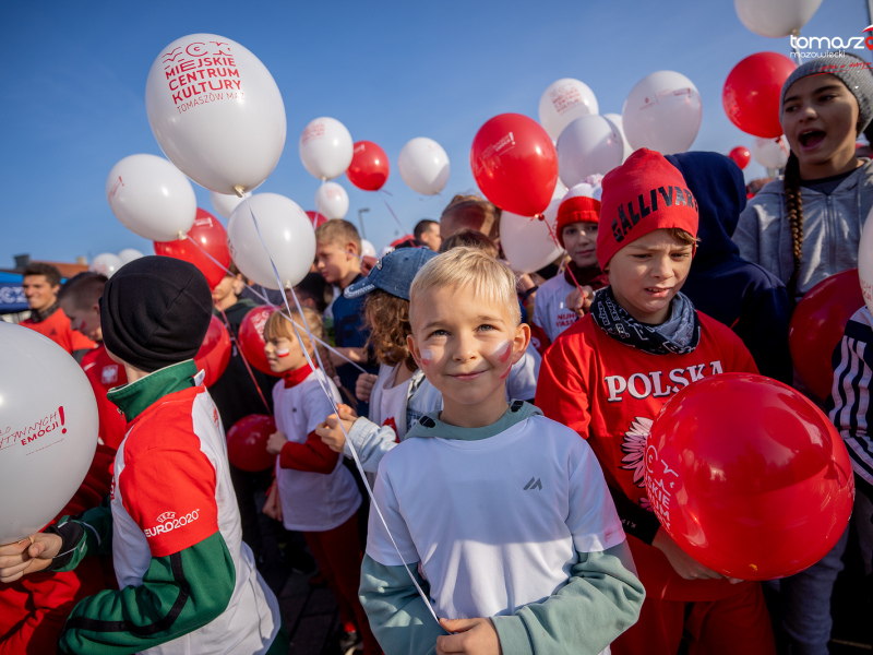 Na zdjęciu grupa dzieci w biało-czerwonych koszulkach z biało-czerwonymi balonami