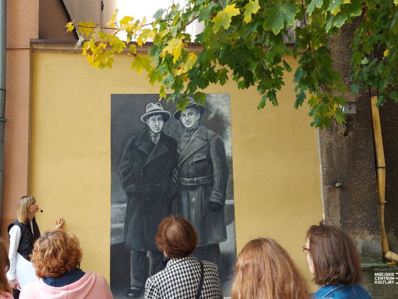 Na zdjęciu uczestnicy spaceru szlakiem tomaszowskich murali sstoja przed jednym z nich