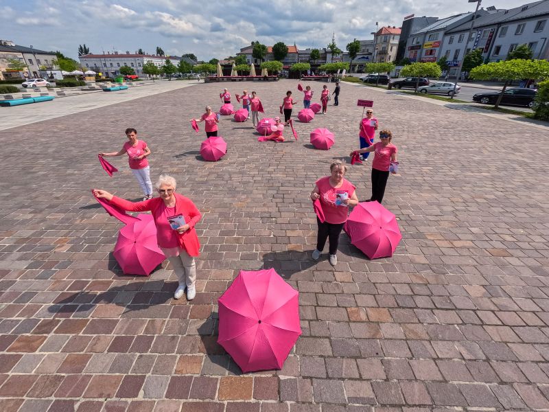 Na zdjęciu członkinie Tomaszowskich Amazoonek podczas promocji profilaktyki na rzecz leczenia nowotworów. Panie ubrane na rózowo z różowymi parasolkami utworzyły figurę wstążki na płycie głownej placu Kościuszki