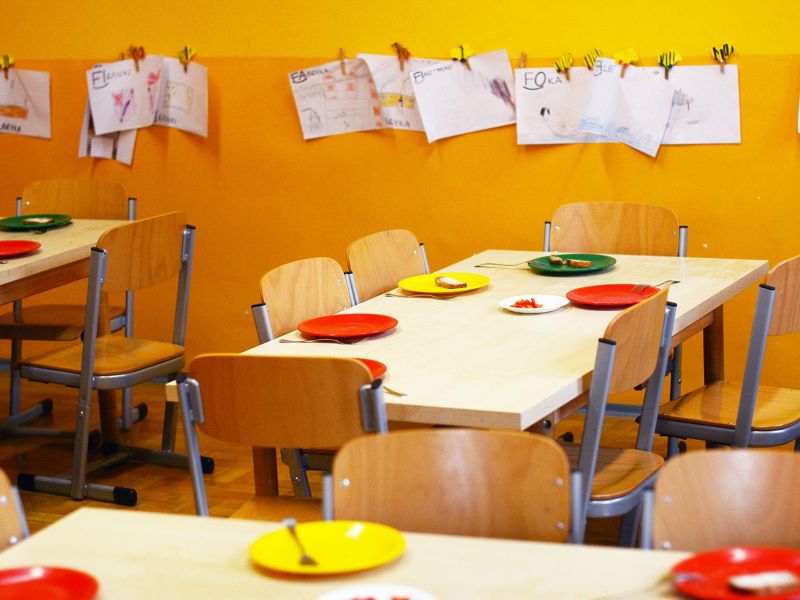 Na zdjęciu sala przedszkolna, stoliki po posiłku, na ścianach rysunki dzieci
