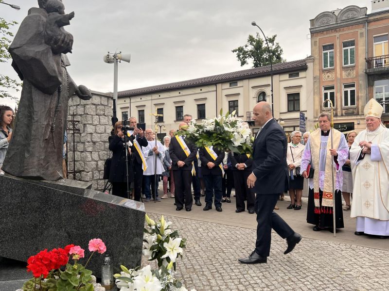 Na zdjęciu prezydent miasta składa kwiaty pod pomnikiem św. Antoniego. W ręku trzyma bukiet lilii.