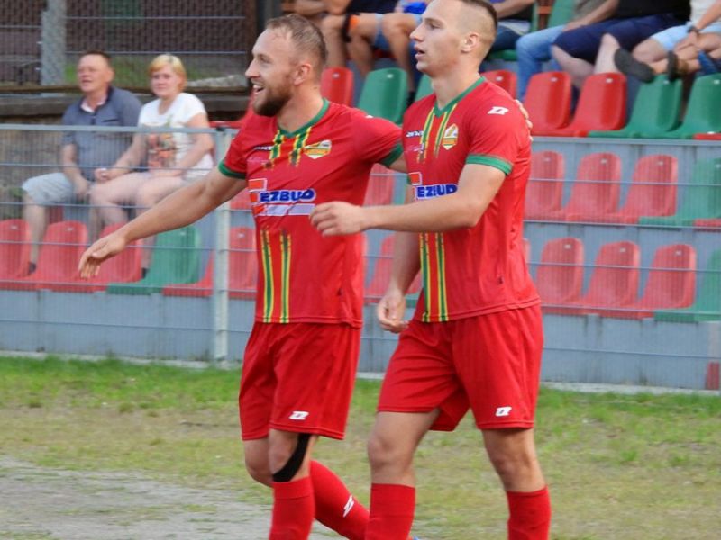 Na zdjęciu dwaj piłkarze Lechii na boisku podczas meczu w czerwonych koszulkach klubowych