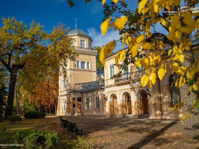 na zdjęciu gmach Muzeum w tomaszowie Mazowieckim w antruazu jesiennym. Opadłe liście na placu przed budynkiem, pożółkłe licie jna drzewach przed Muzeum.