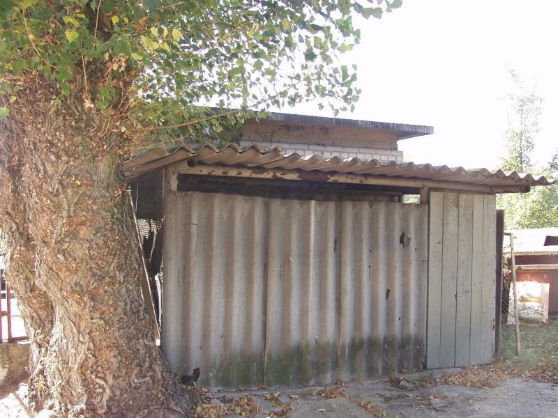 Na zdjęciu stary garaż wykonany z używanych dachówek z azbestu