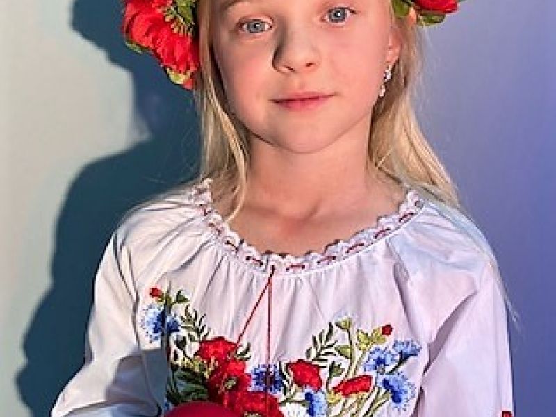 dziewczynka w wianku z kwiatów i czerwonym mikrofonem