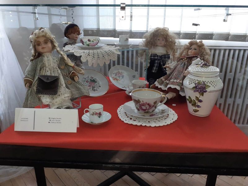 Na zdjęciu lalki wyeksponowane obok zabytkowej porcelany. Wystawa lalek w muzeum 