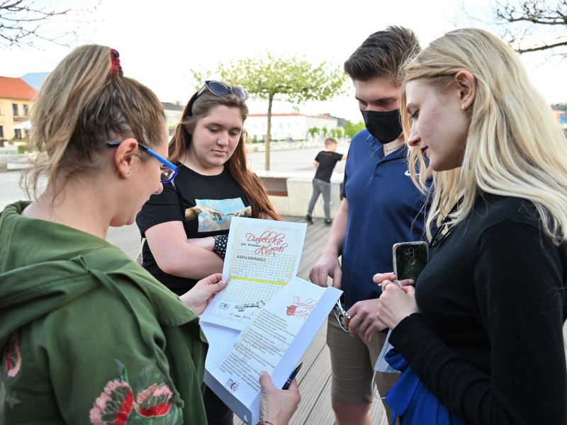 Na zdjęciu uczestnicy gry ulicznej MCK zapoznają się z mapami i zagadkami na płycie placu Kościuszki
